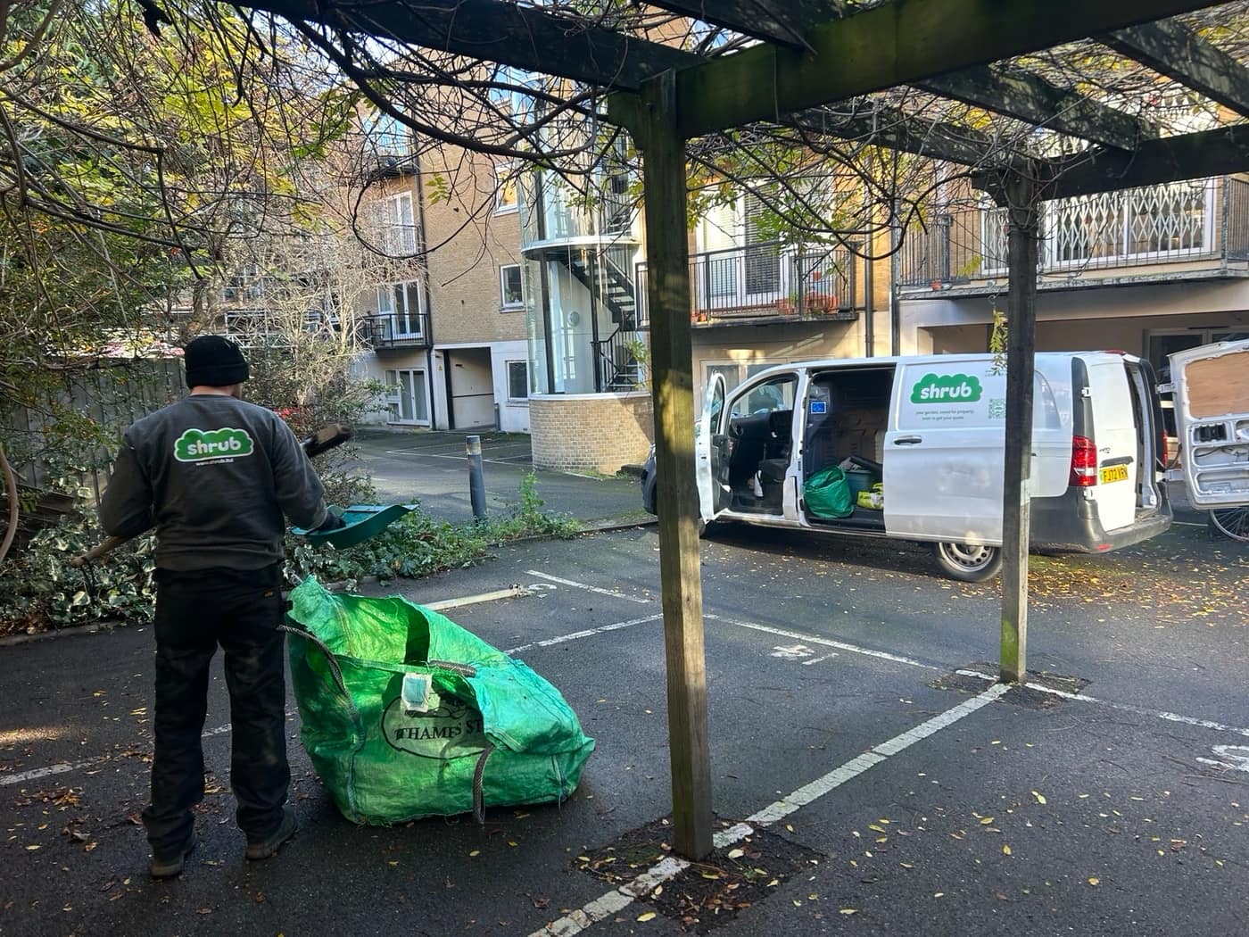 Shrub team member loading green waste bulk bags next to the van after a garden clearance